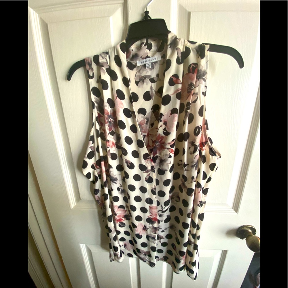Sleeveless cream top with polka dots and floral accents